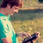 young guy with a tablet outdoors